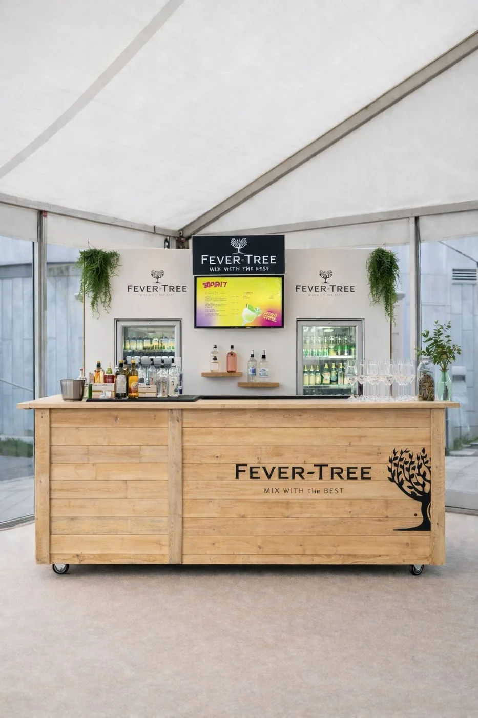 Bar mobile en bois avec écran intégré sous une tente